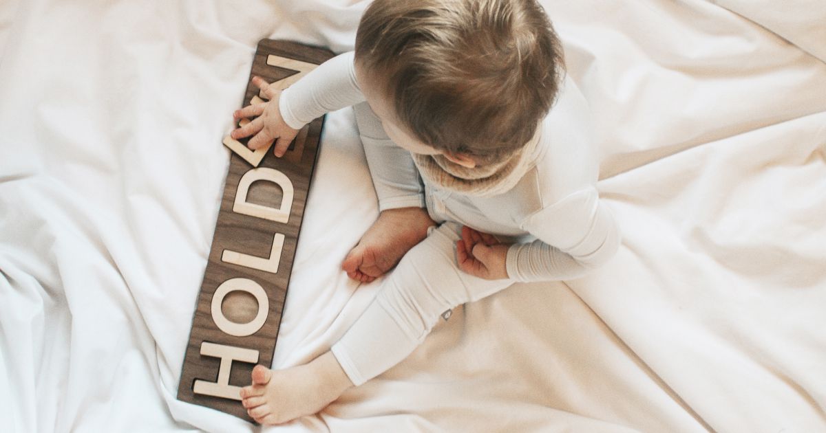 Baby playing with a personalized wooden name puzzle — a beautiful way to support early learning through play.